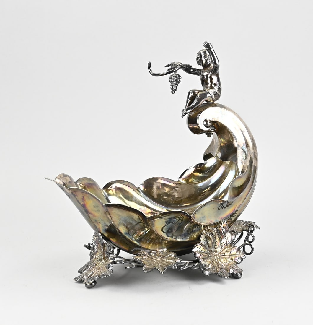 Plated table dish: Plated table dish in the shape of a nautilus shell, with Bacchus and a bunch of grapes. 20th century. Sheffield, England. Dimensions: 29 x 29 x 7 cm. In good condition.