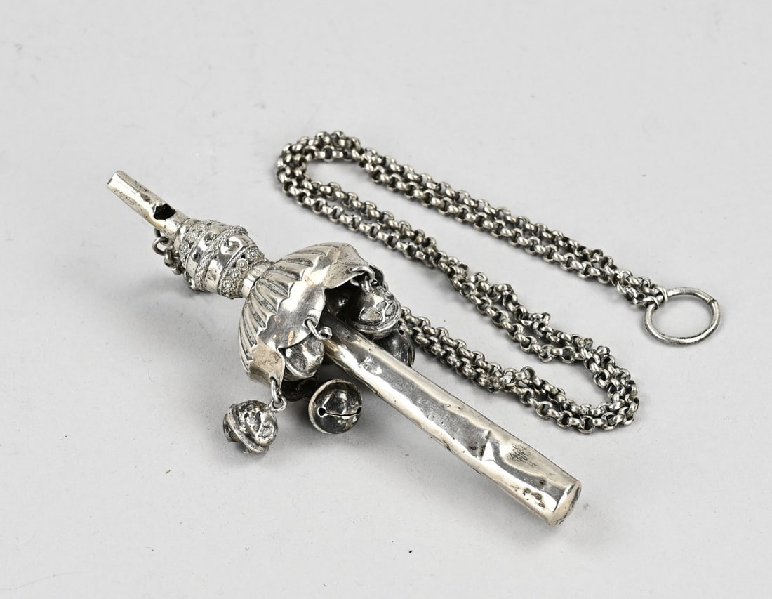 Silver rattle: Silver rod rattle, 833/000, parasol-style with bells. Equipped with a whistle. A jasseron chain is attached to the rattle. A few small dents. Approx. 65 grams. 13 cm. Slightly out of shape, otherwise