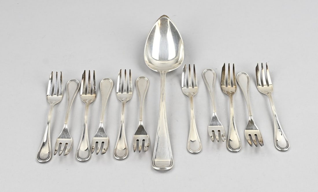 Silver cake forks and spoon: Lot of silver cake forks and serving spoon with filigree rim. 11 cake forks, 800/000, 100 PD, Padova Italy, and a serving spoon, 833/000, MT.: Van Kempen, Voorschoten, jl.:E:1914. with monogram