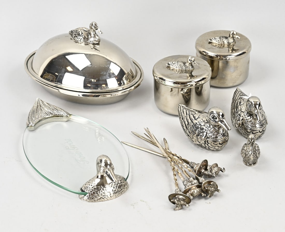Lot of Plated Ducks: Lot of various plated items featuring ducks. A serving dish with lid, five skewers, an oval glass tray with duck heads as holders, a small candlestick in the shape of a duck, and 2 small boxes with