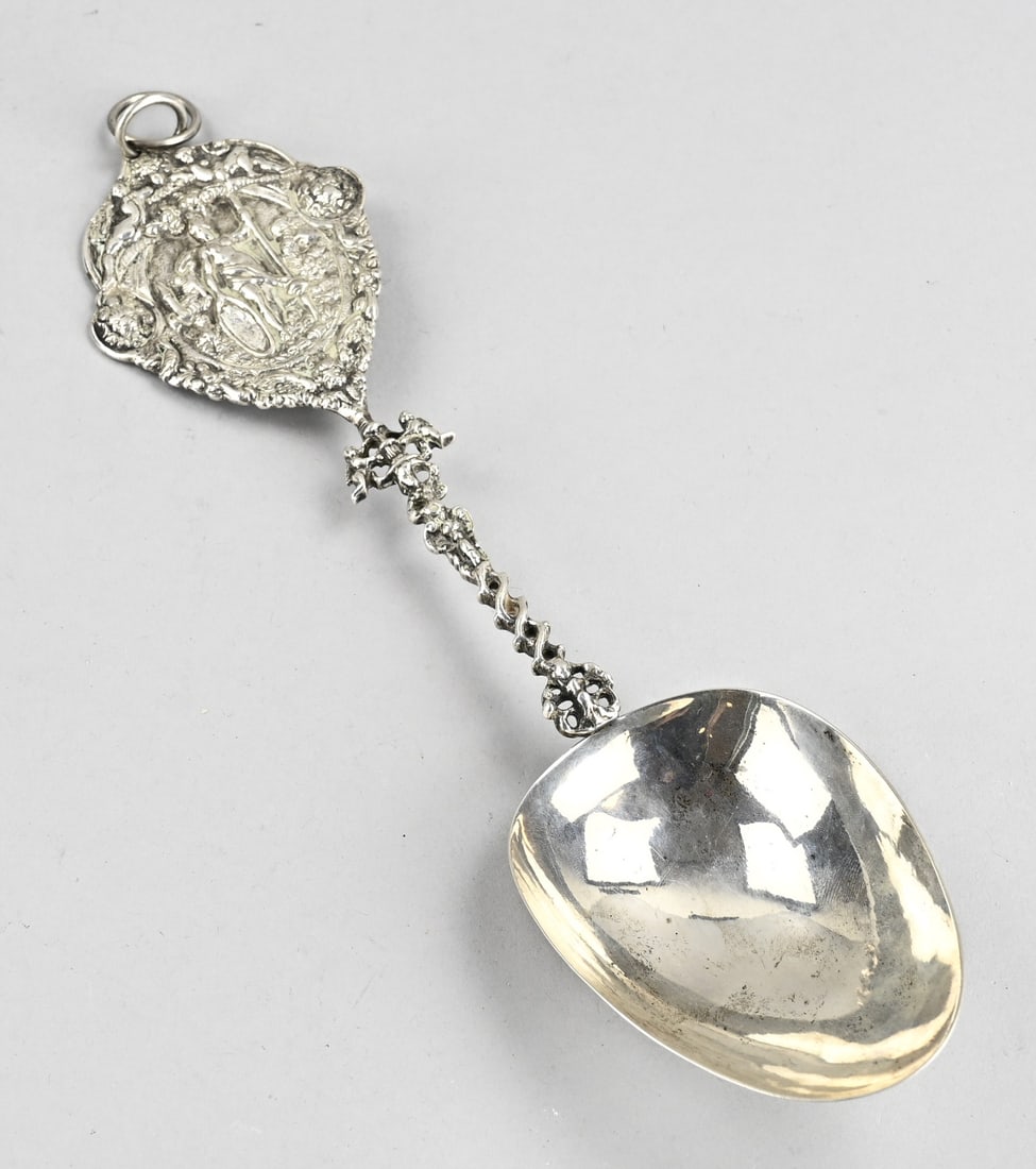 Silver decorative spoon: Large silver ornamental spoon, 833/000, with a twisted handle fitted with a pear-shaped bowl and a pear-shaped shield decorated with figures. Fitted with 2 hanging loops. 32 cm. approx. 168 grams. In