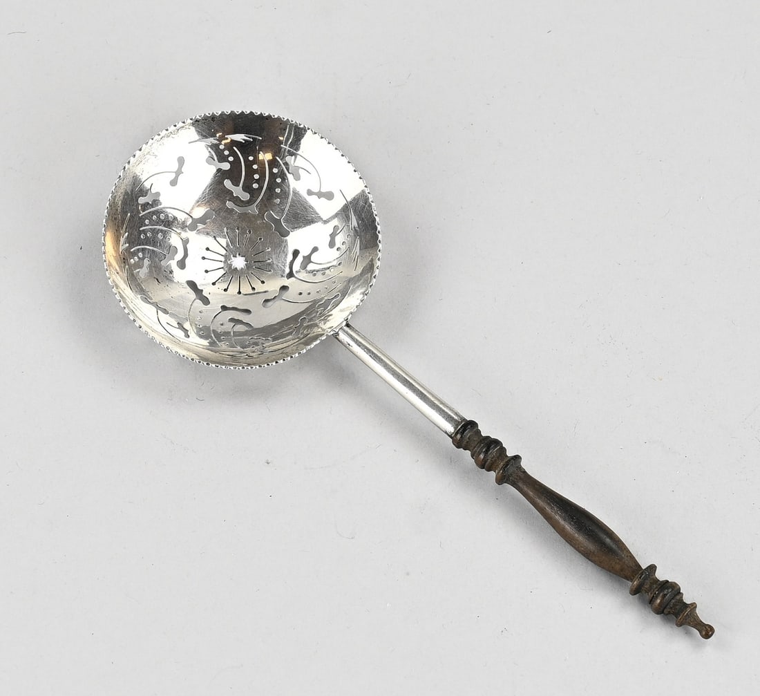Silver sugar shaker: Silver sugar spoon, 833/000, with a round sawn bowl featuring a serrated edge. The bowl has a partially wooden handle. MT.: RH, Amsterdam. 19x7cm. approx. 33 grams. In good condition.