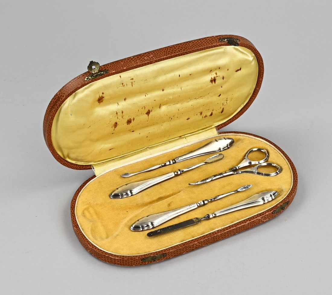 Silver manicure set (cassette): Cassette with silver manicure set, 835/000. Cassette filled with scissors, a file, and 3 cuticle accessories, all with silver contoured handles. 13.5x24cm. In reasonably good condition.