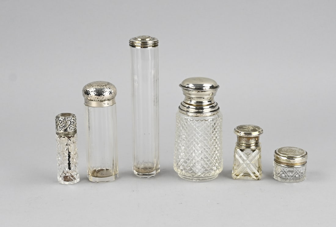 6 Bottles with silver: Six crystal flasks with silver caps. 925/000 and 800/000. Flasks with various cuts and silver caps, some with engraving. A few small dents, otherwise in good condition. 3-17cm.