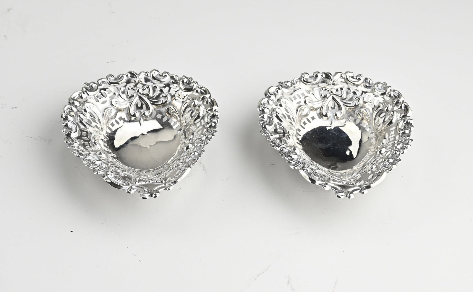 2 silver bowls: Two small silver dishes, 925/000, pear-shaped model with stamped decoration of curls and bows. Mounted on 3 feet. MT.: S.Blanckensee & Bon Ltd, Birmingham, 1897. Total weight approx. 32 grams. 8x9x3cm