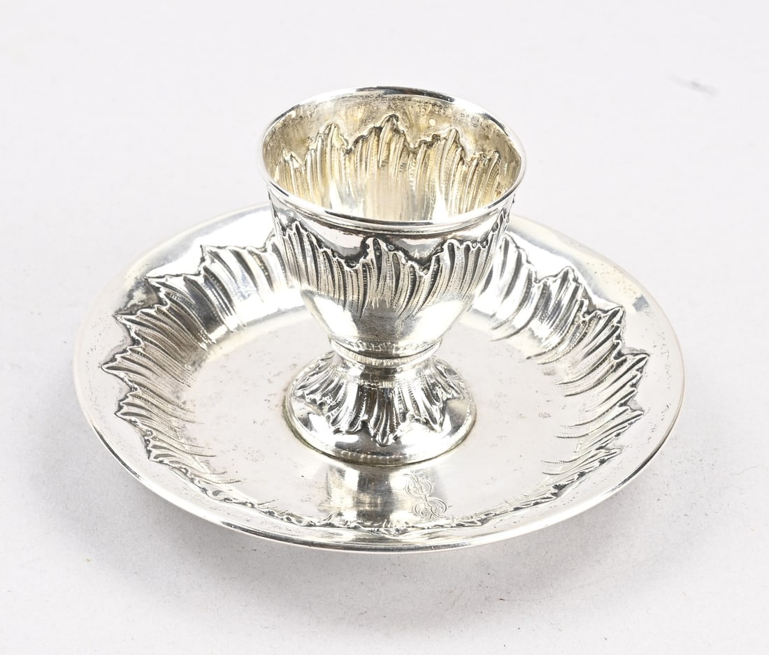 Silver egg cup: Fine silver egg cup, 800/000, on a fixed round saucer with leaf decoration, featuring a monogram engraving, and a round egg cup with leaf decoration. Approx. 123 grams. ø11.5x4.5cm. In good