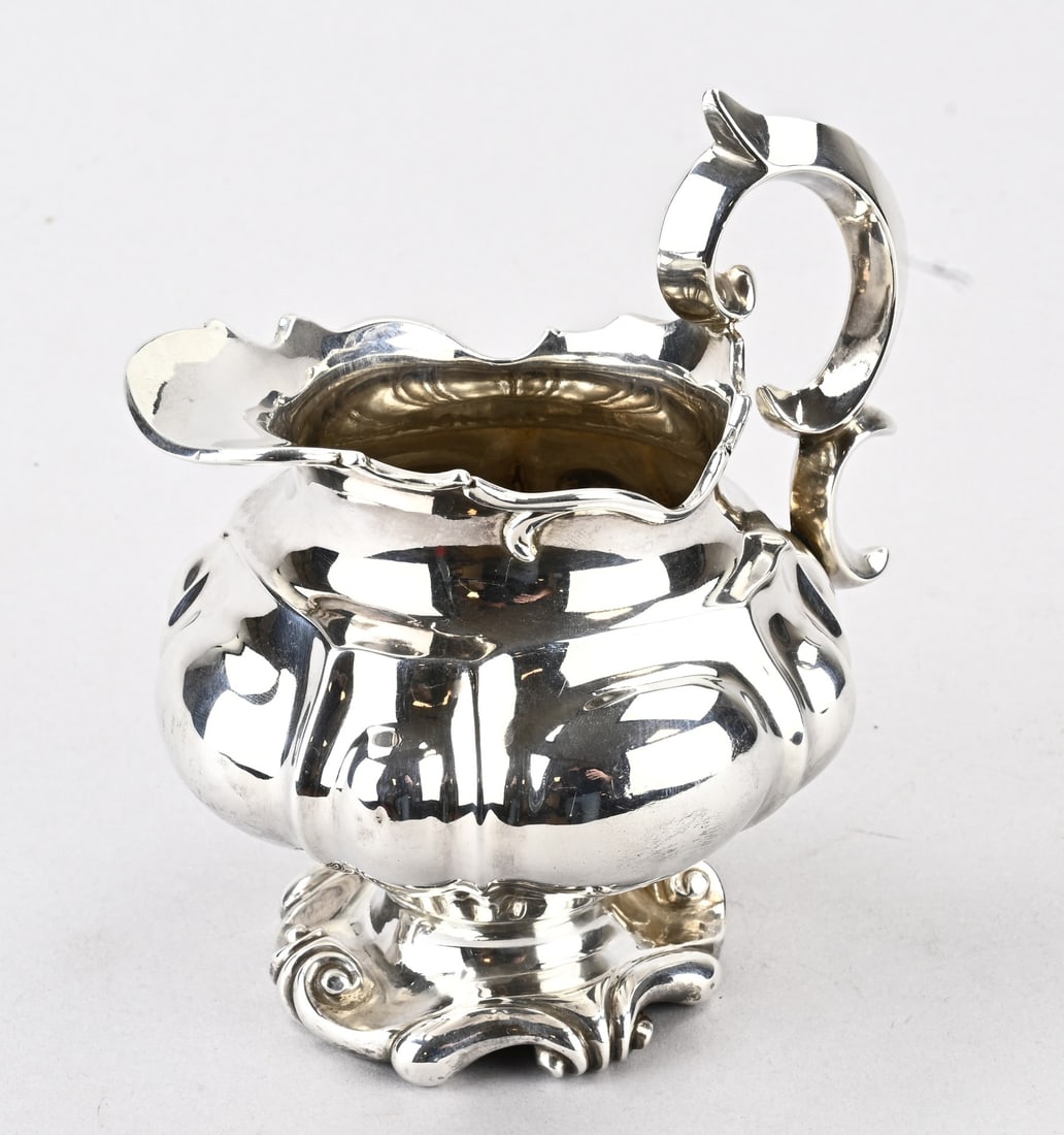 Silver jug: Silver milk jug, 934/000, contoured model on a foot with curls and ribs. MT.: JDArnoldus & JWWiellick, Amsterdam. jl.:N:1847. 12x10x14cm. approx. 231 grams. In good condition.