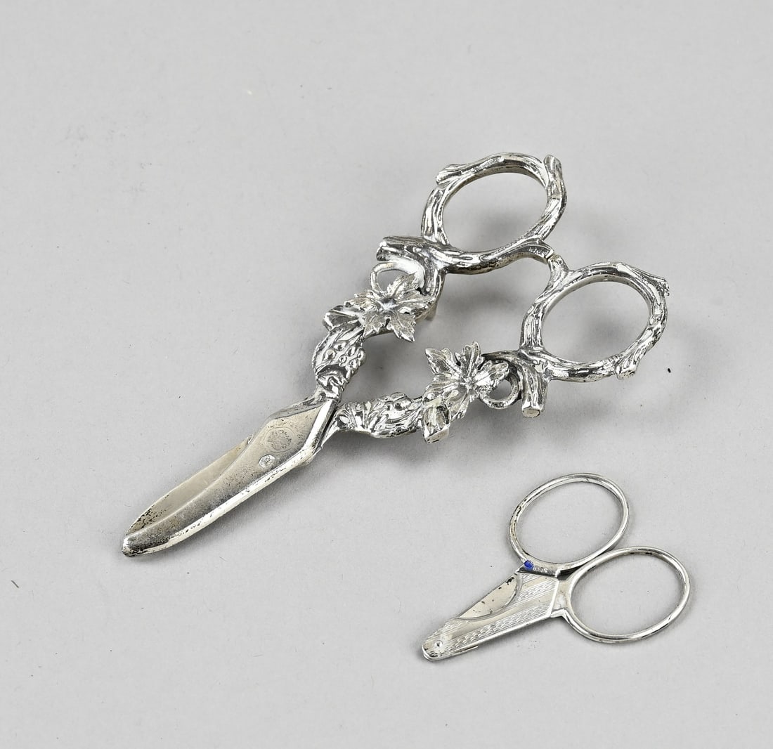 Silver scissors & cigar cutter: Silver scissors, 833/000, and cigar cutter, 830/000. Grape scissors with handles decorated with grapevines, 12 cm. And a cigar cutter with guilloche line work. 5x3cm. Total approx. 57 grams. In good