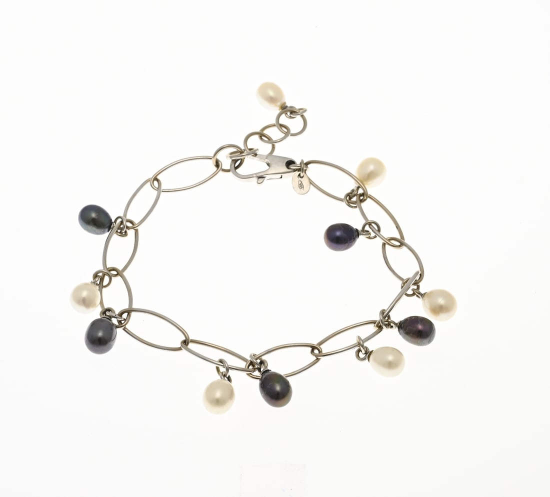 White gold bracelet with pearls: White gold bracelet, 585/000, with pearls. Bracelet of marquise-shaped wire links decorated with 11 white, grey, and black freshwater pearls. Length 18.5-21 cm. Approx. 11.5 grams. In good condition.