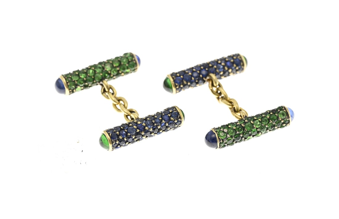 Gold cufflinks with sapphire and emerald.: Exceptional yellow gold cufflinks, 750/000, with 2 cylindrical elements, one pave set with sapphires and one pave set with emeralds. Cabochon-cut stones are set at the ends of the cylinders. Cylinder
