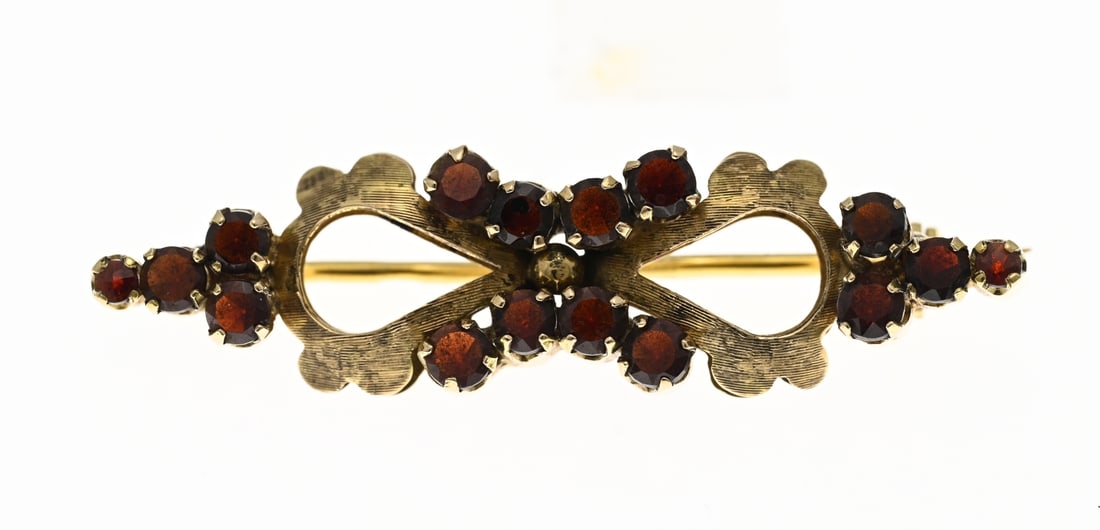 Gold brooch with garnet: Yellow gold brooch, 585/000, with garnet. Contoured brooch with a matte finish and set with faceted garnet stones set in 4 prong settings. Approx. 5.9 grams. 12x46mm. In good condition.