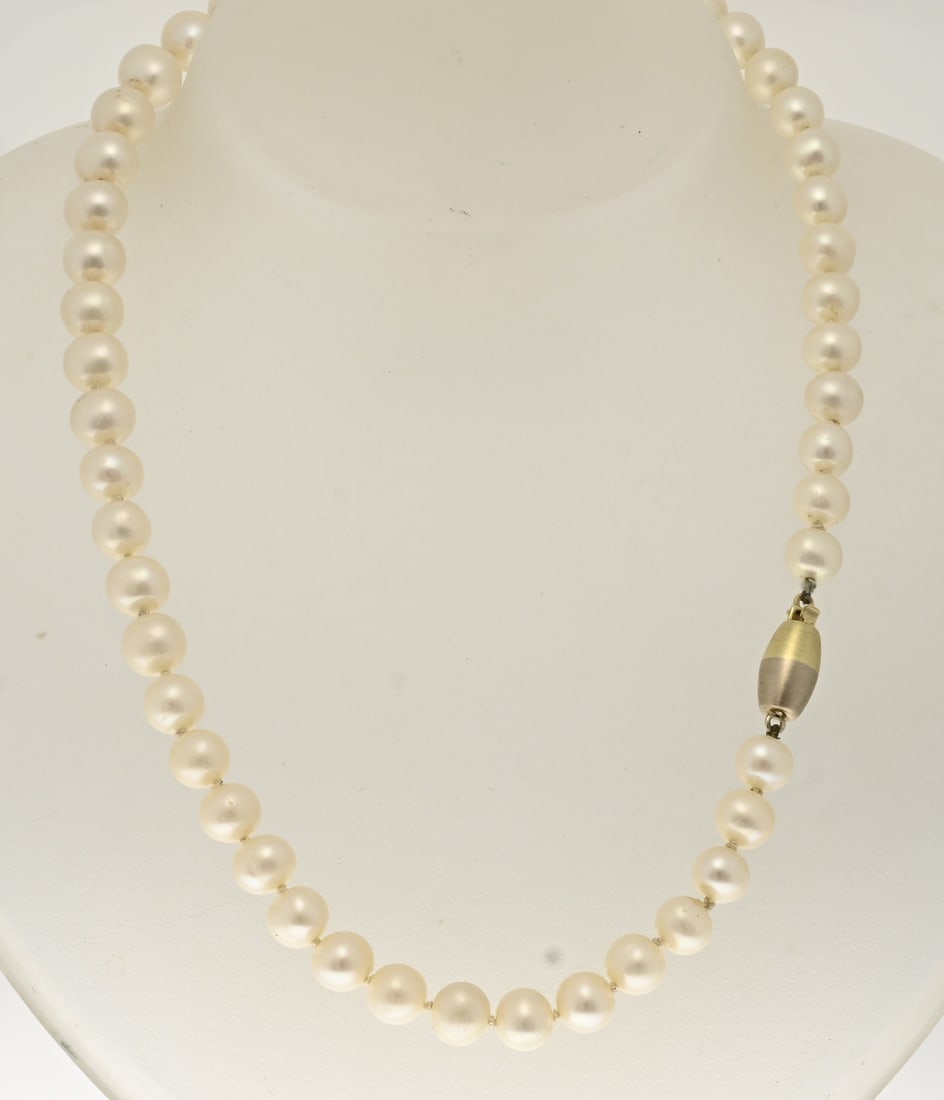 Pearl necklace with gold clasp: Necklace of freshwater pearls, ø 8 mm, attached to an oval matte gold clasp, 585/000, half white and half yellow gold. Length 43 cm. In very good condition.