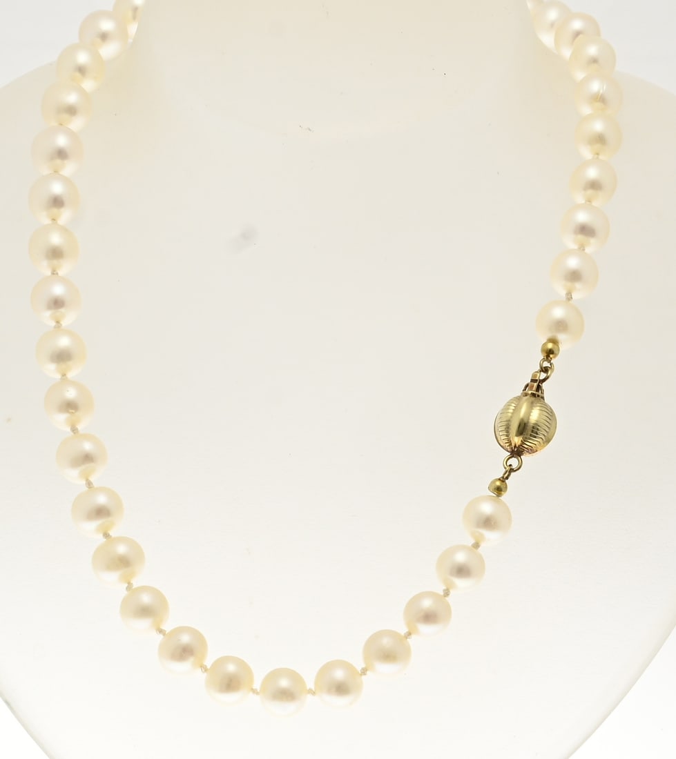 Pearl necklace with gold clasp: Necklace of large freshwater pearls, ø 9 mm, knotted to a yellow gold ball clasp, pumpkin-shaped with alternating rib decoration. 585/000. Length 43 cm. In good condition.