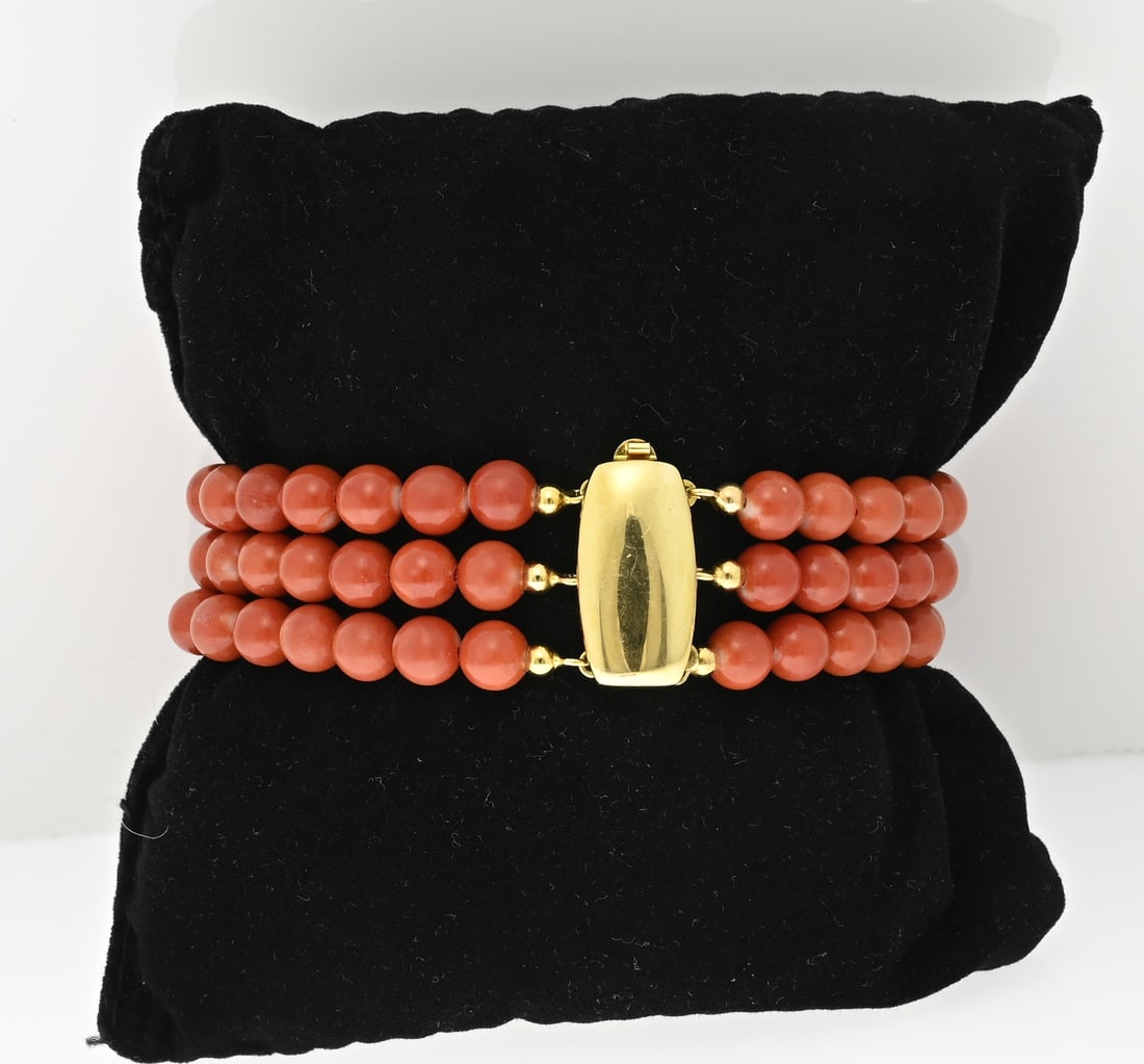 Blood coral bracelet: Bracelet with red coral on a yellow gold clasp, 585/000. Bracelet with 3 rows of red coral, round beads ø 6 mm, attached to an oval-shaped yellow gold clasp. Width 19.5 mm. Length 18.5 cm. And 31 cm