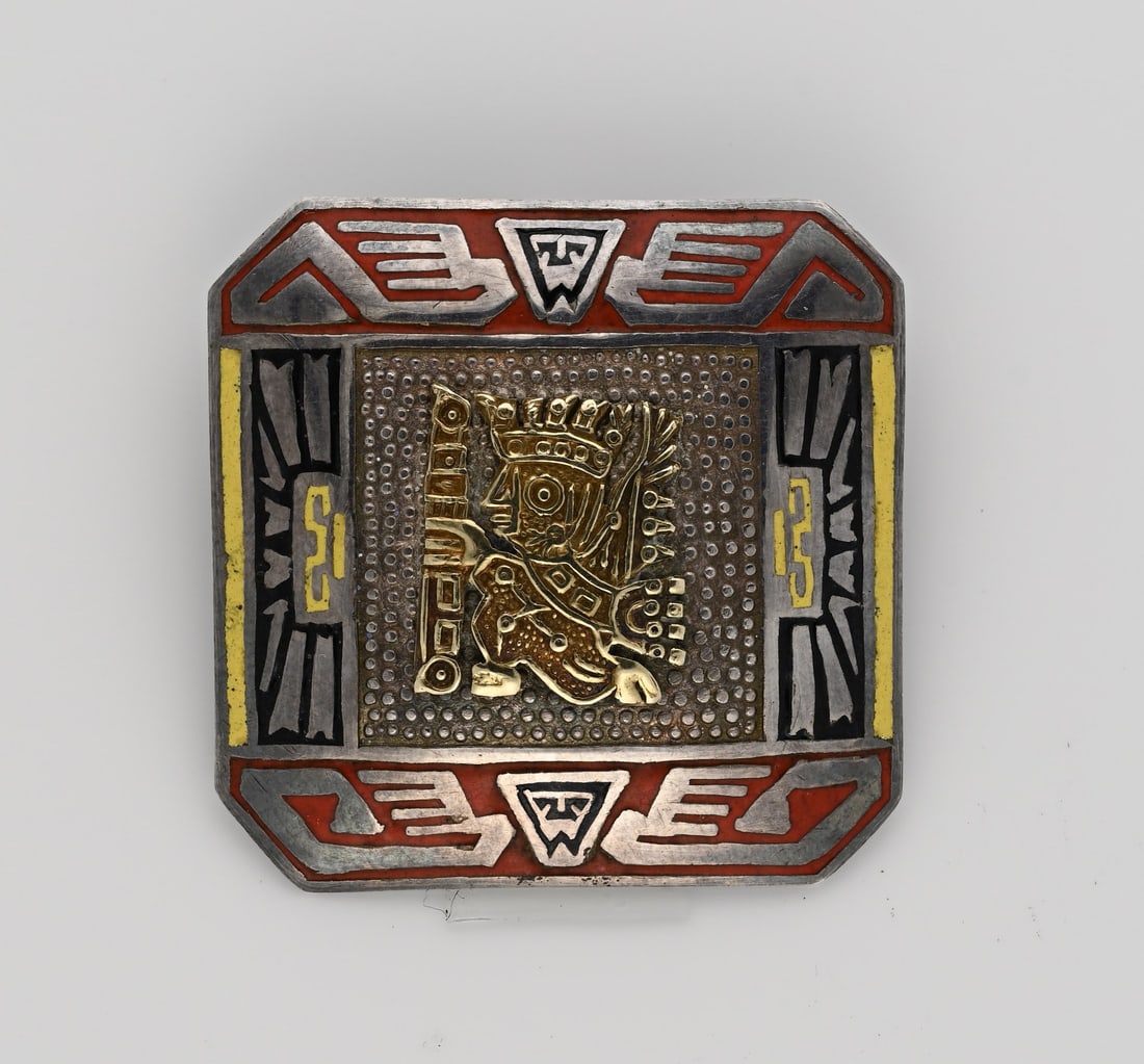 Silver with gold brooch Peru: Silver brooch, 925/000, with yellow gold element, 750/000. Square contoured brooch, decorated with enamel and a yellow gold Inca element. Marked: Peru PML. The brooch also features a suspension loop.