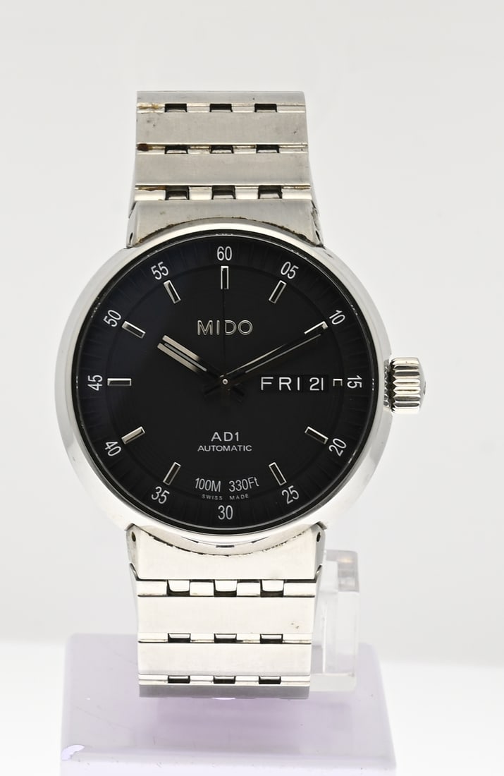Mido watch: Mido steel watch, AD1 Automatic, round case with a black dial featuring day and date display. Case diameter 38 mm. Mounted on a steel bracelet. Fitted with a glass case back. With sapphire crystal.