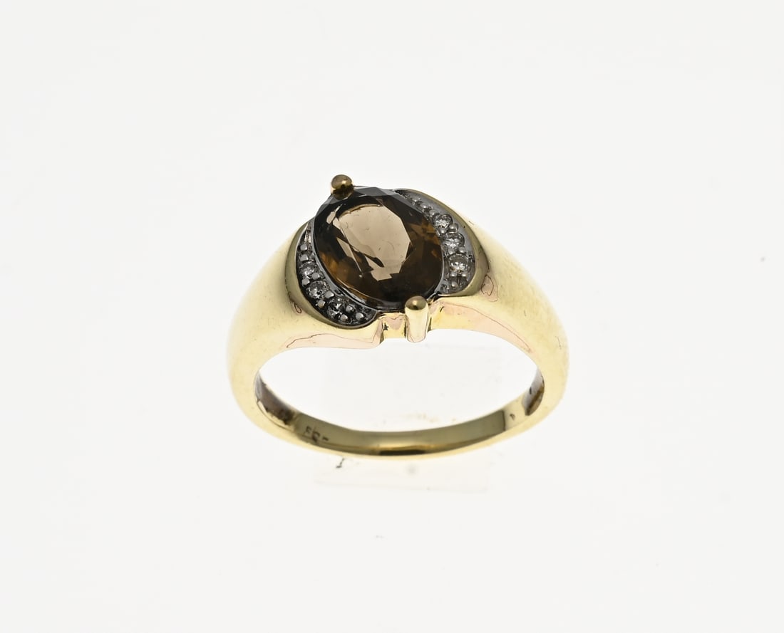 Gold ring with smoky quartz and diamond: Yellow gold ring, 585/000, with smoky quartz and diamond. Ring with a twist and an oval faceted smoky quartz with a bezel featuring a total of 6 small diamonds. Head width 11 mm. Approx. 5.3 grams. ø