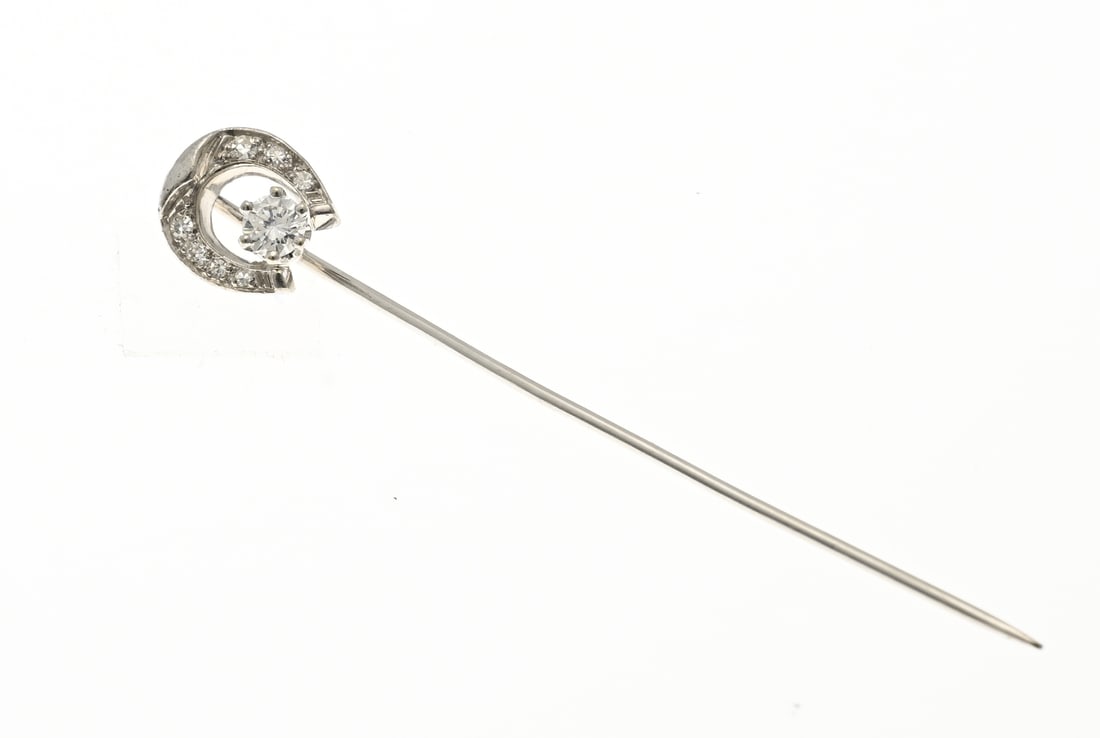 White gold horseshoe tie clip with diamond: White gold tie clip, 750/000, with diamond. Horseshoe-shaped tie clip with 7 single-cut diamonds, total approx. 0.09 ct., and in the center a brilliant-cut diamond in a six-prong setting, approx.