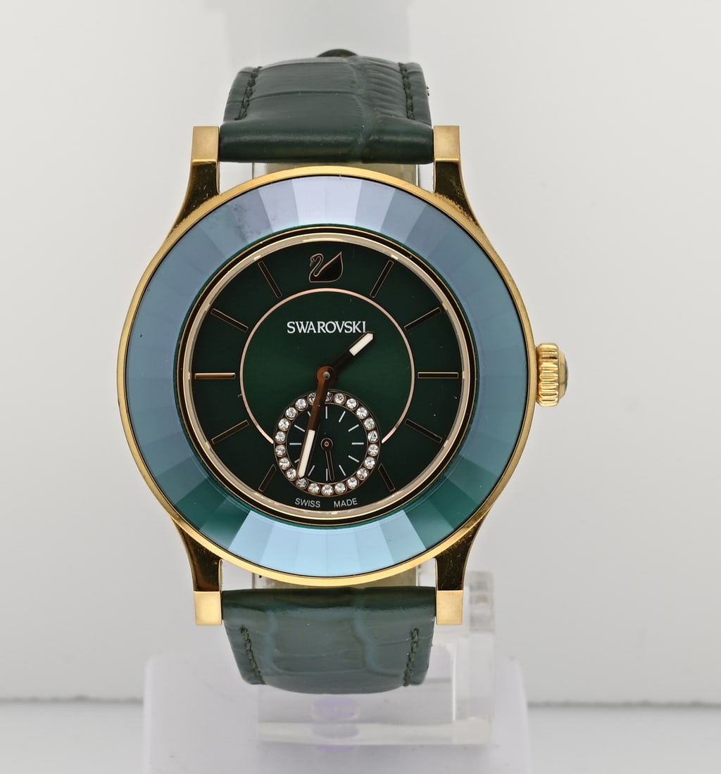 Swarovski watch green: Beautiful Swarovski watch, Octea, with a green bezel, dial, and leather strap. With a gold-colored case. Quartz. Working. ø 39 mm. As new.