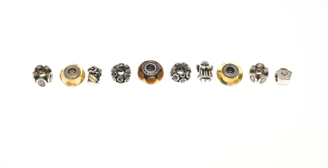 Pandora charms, 10x: Ten silver Pandora charms, 925/000, with 3 Murano glass charms, 5 charms with colored cubic zirconia, an angel-shaped charm, and a flower basket charm with a yellow gold element. Total approx. 33.5