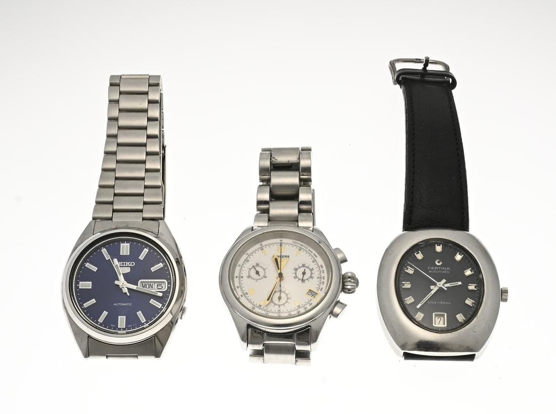 3 Watches, steel strap: Three steel watches: a Seiko 5 automatic with a blue dial featuring day and date. An oval Certina automatic watch, Blue Ribbon, with a black dial and date display. And a round Junkers chronograph watc