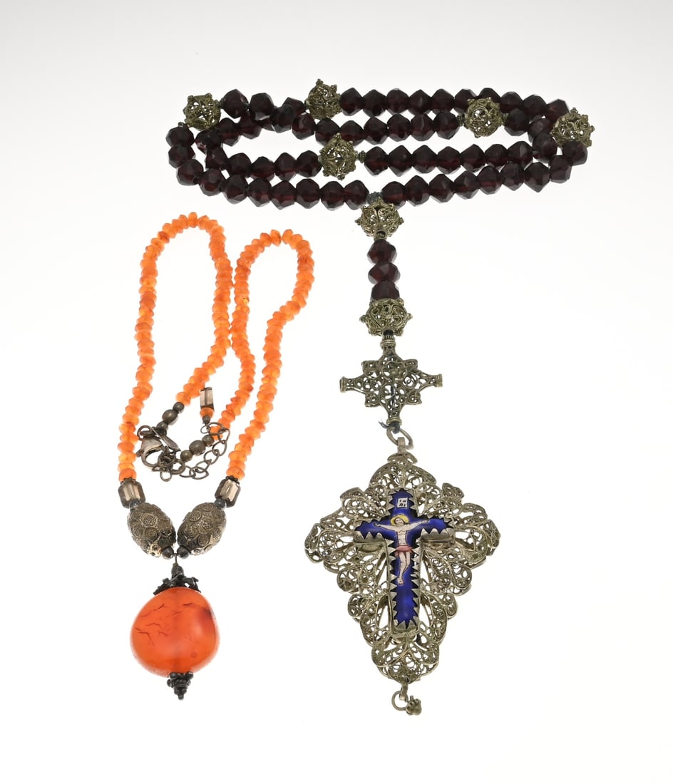 2 Necklaces with pendants: Two necklaces with pendants. A necklace with faceted garnet beads and filigree spheres, fitted with a cross-shaped pendant featuring a blue enamel cross-shaped element. And a necklace of carnelian