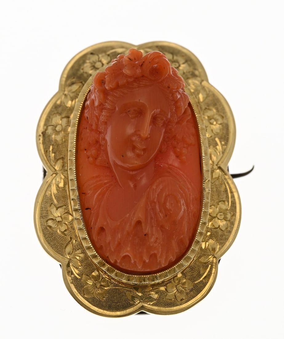 Gold brooch with blood coral: Exceptional yellow gold brooch, 585/000, with a carved blood coral. Oval brooch with a scalloped edge featuring an ornate engraved border and an oval carved blood bead depicting a female figure. With