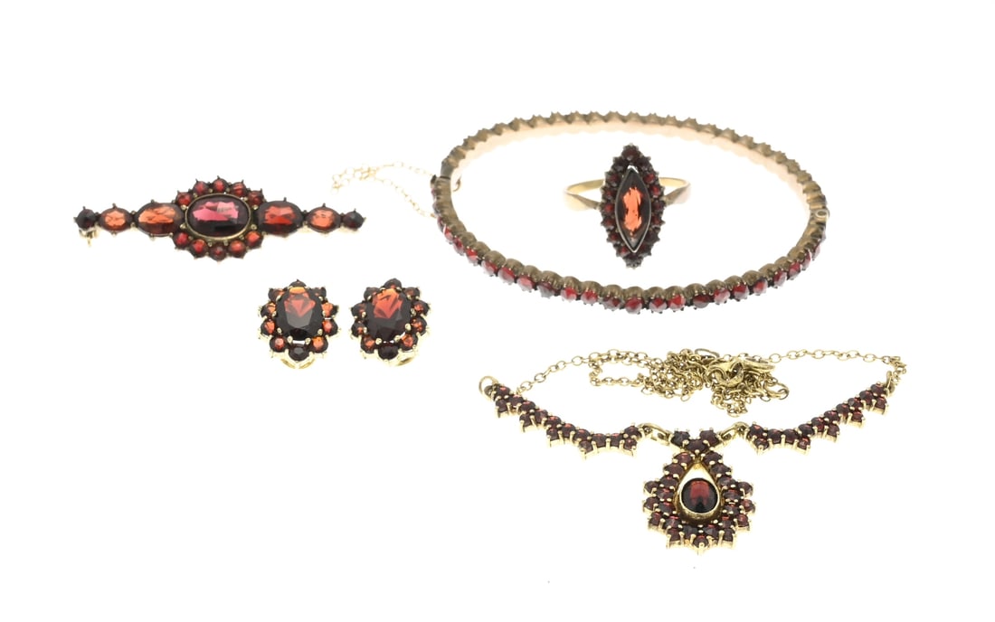 Lot of garnet jewelry, 5x: Lot of 5 gold-plated pieces of jewelry set with garnet. A choker, a bangle, a ring, ear clips, and a brooch with garnet stones. One bangle is made from a band of garnet stones, and the other pieces fe