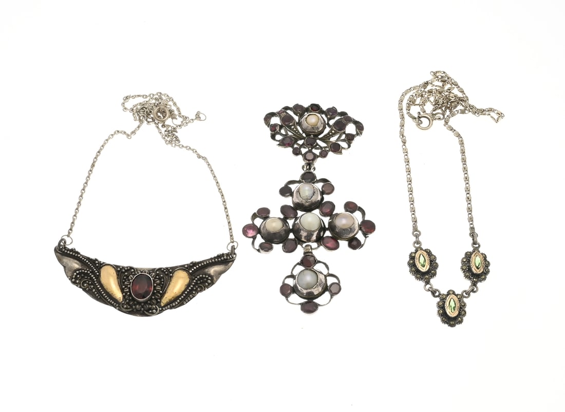 Lot of jewelry with garnet: Three pieces of jewelry: a large cross-shaped pendant with pearls and stones in various shades of pink, 7.5 cm. And two silver chokers: one with a V-shaped element with grains, a red stone, and gold