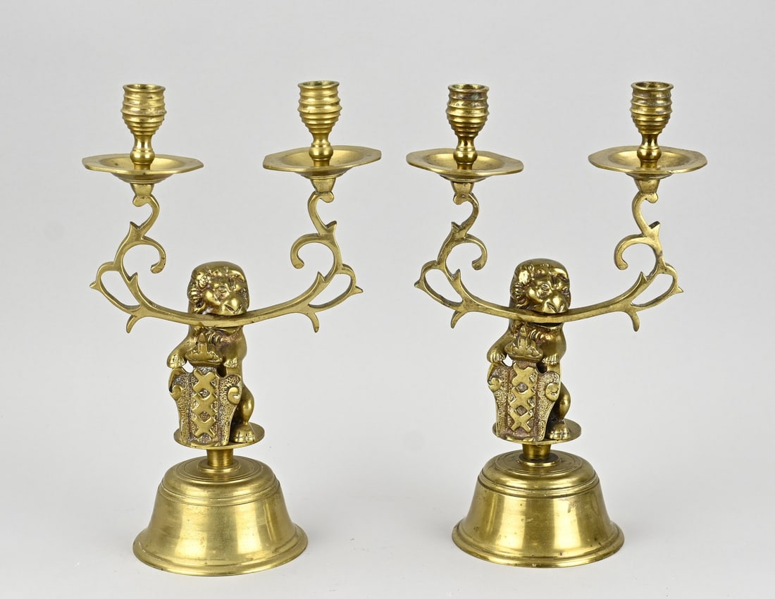 2 Amsterdam candlesticks, 1920: Two Amsterdam brass candlesticks with city coat of arms and lions. Circa 1920. Dimensions: H 29 x 30 cm. In good condition.