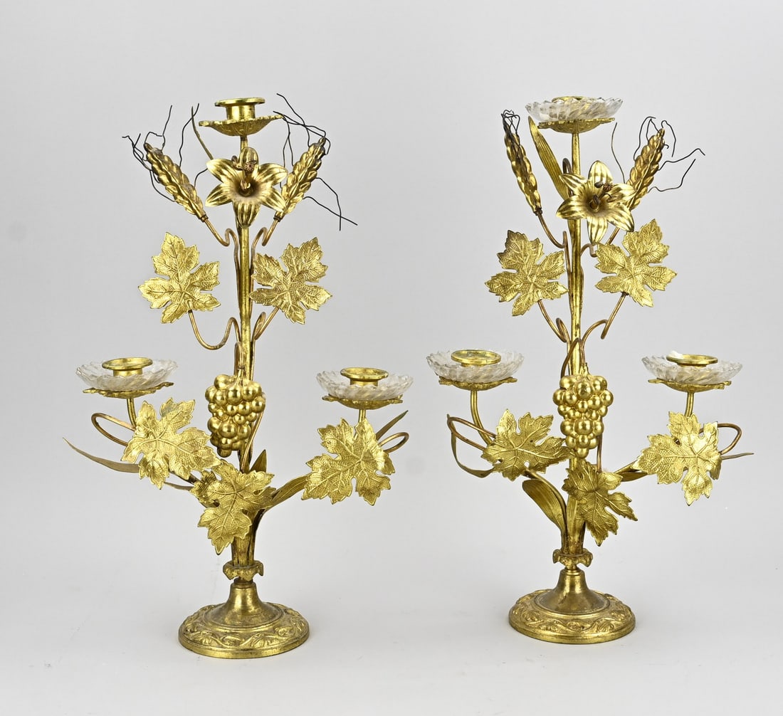 2x French candlestick, H 46 cm.: Two antique gilded brass candlesticks with glass bobeches (one missing) and decoration of grapevines/ears of corn. Dimensions: H 46 cm. In good condition.