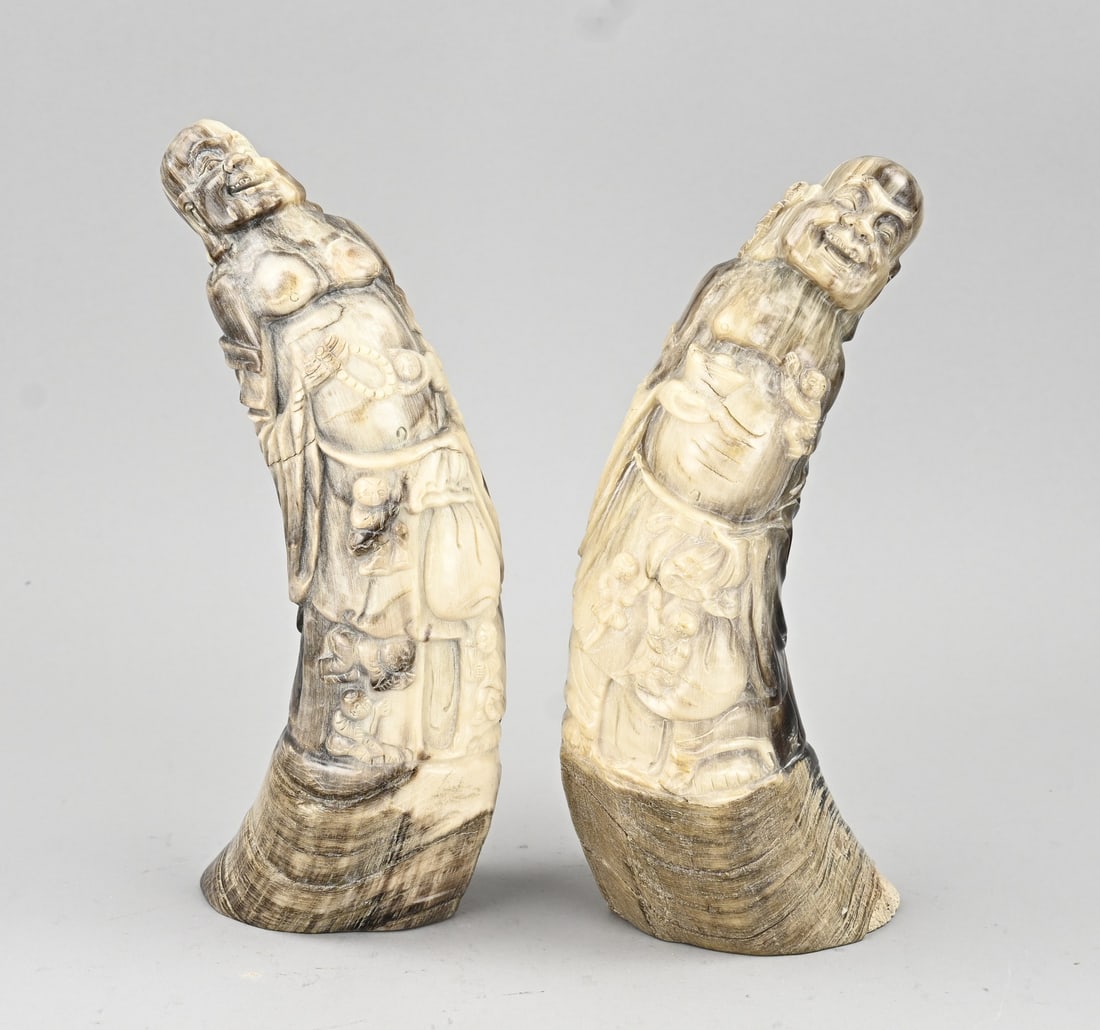 2x Carved buffalo horn, 25 - 27 cm.: Two carved Chinese buffalo horns, with Buddha carvings and jesters. 20th century. Dimensions: 25 x 27 cm. In good condition.