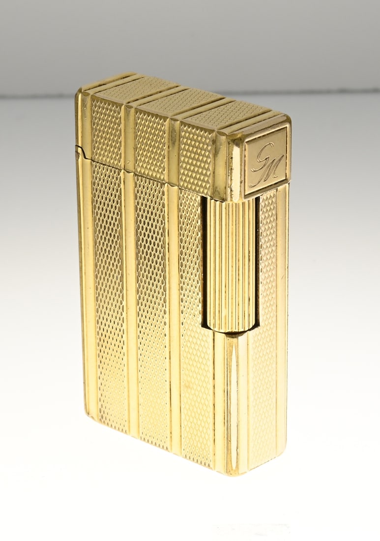 Dupont lighter.: Gold-plated St. Dupont lighter with guilloche decoration, 4 bands. No.: 16AEV69. 33x55x12mm. Clear signs of use. With monogram GM.