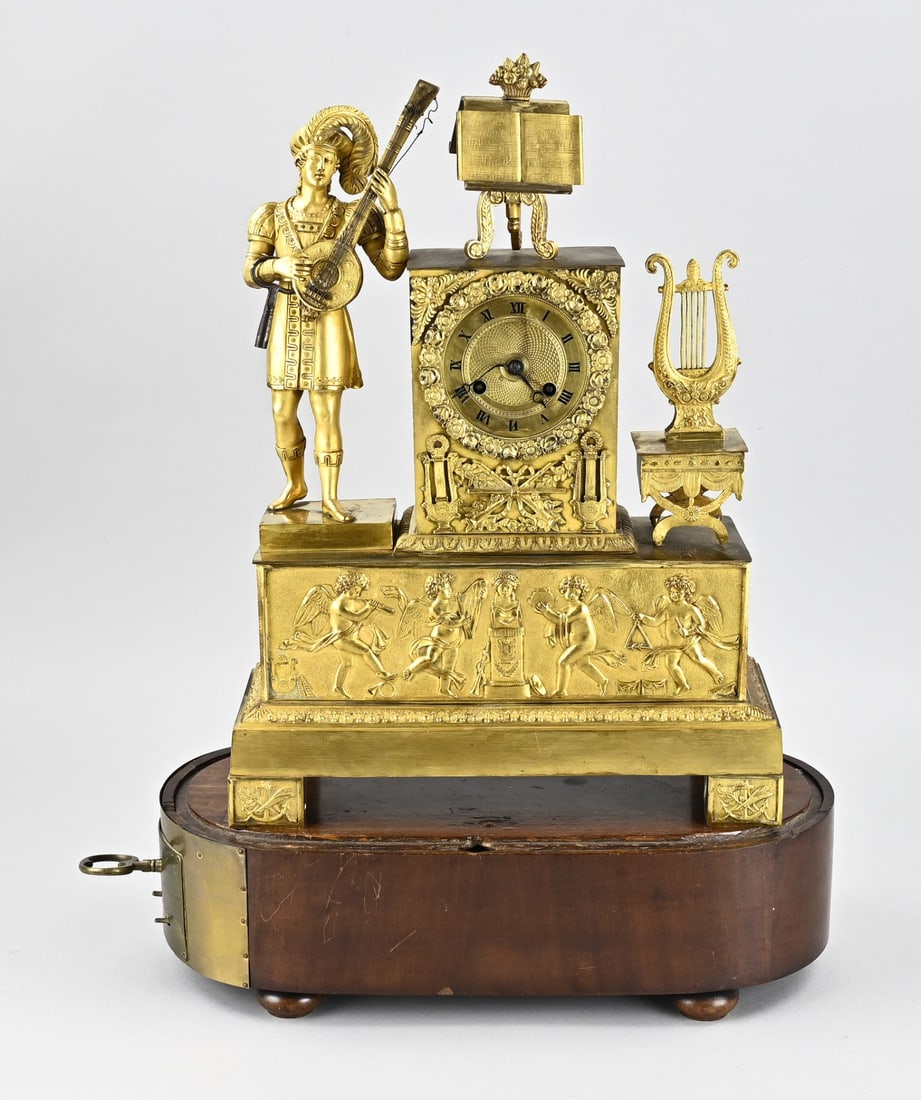 Empire pendulum clock, 1820: Antique, French, fire-gilded bronze Empire pendulum clock with mechanism for connection to a music box (connection missing). Circa 1820. Eight-day movement, half-hour strike, string pendulum.