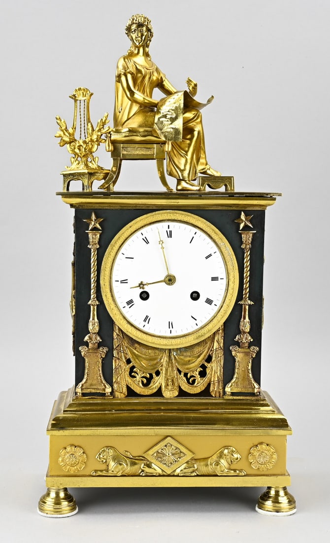 French empire mantel clock, H 47.5 cm.: Beautiful, pristine French fire-gilded Empire clock. Woman with sheet music and lyra. Circa 1820. Eight-day movement, half-hour strike, cord pendulum. Dimensions: H 47.5 cm. In good working condition.