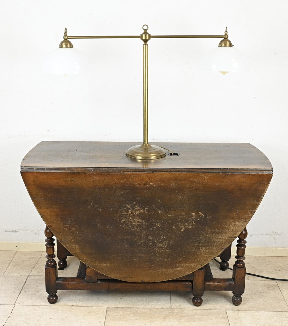 Oak gate-leg table with lamp: English oak drop-leaf table with drawer and mounted brass lamp. Dimensions: 76 x 121 x 180 cm. In good condition.