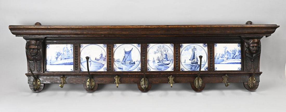 Coat rack inlaid with 6 tiles: 19th-century oak coat rack with six antique 19th-century blue tiles. One tile is cracked, the rest is intact. One small frame is missing from the back left. Dimensions: 116 x 28 x 10 cm. In good