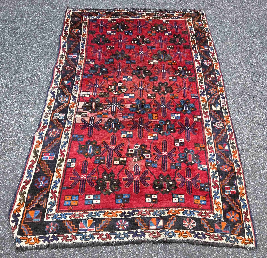 Persian rug, 250 x 155 cm.: Hand-knotted Persian rug. Color: red, with a light border; a section on the side has been restored at some point. Dimensions: 250 x 155 cm. In fair/good condition.
