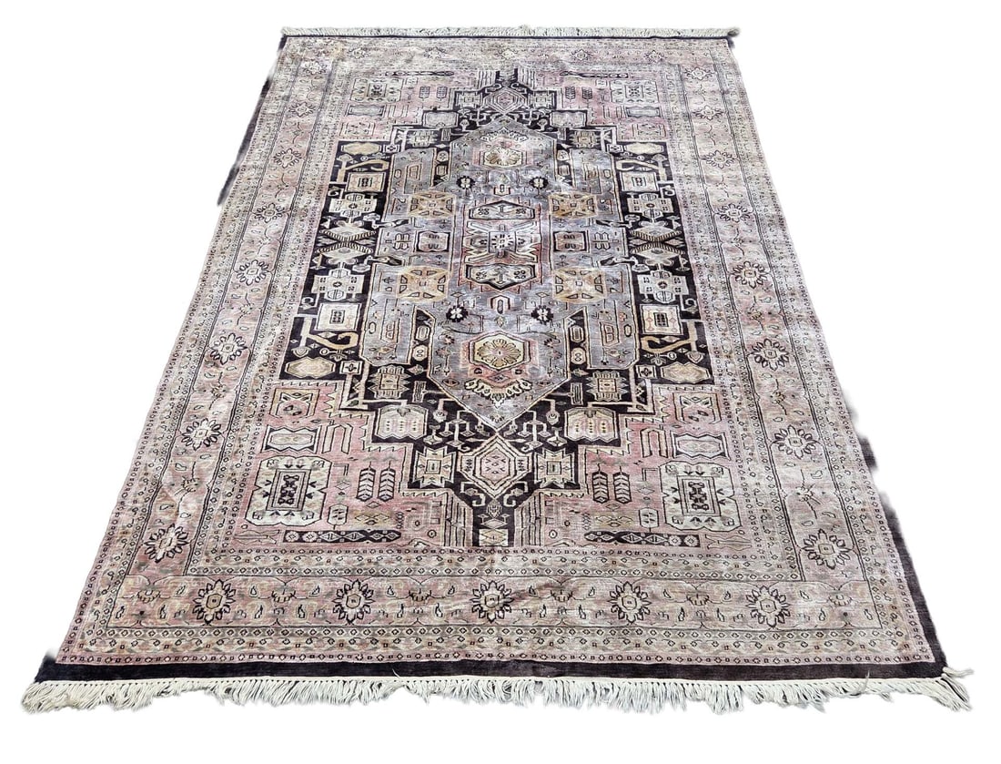 Persian silk rug, 290 x 185 cm.: Hand-knotted Persian silk rug. Light in color, with a dark blue border. Dimensions: 290 x 185 cm. The rug is slightly faded, but otherwise in good condition.