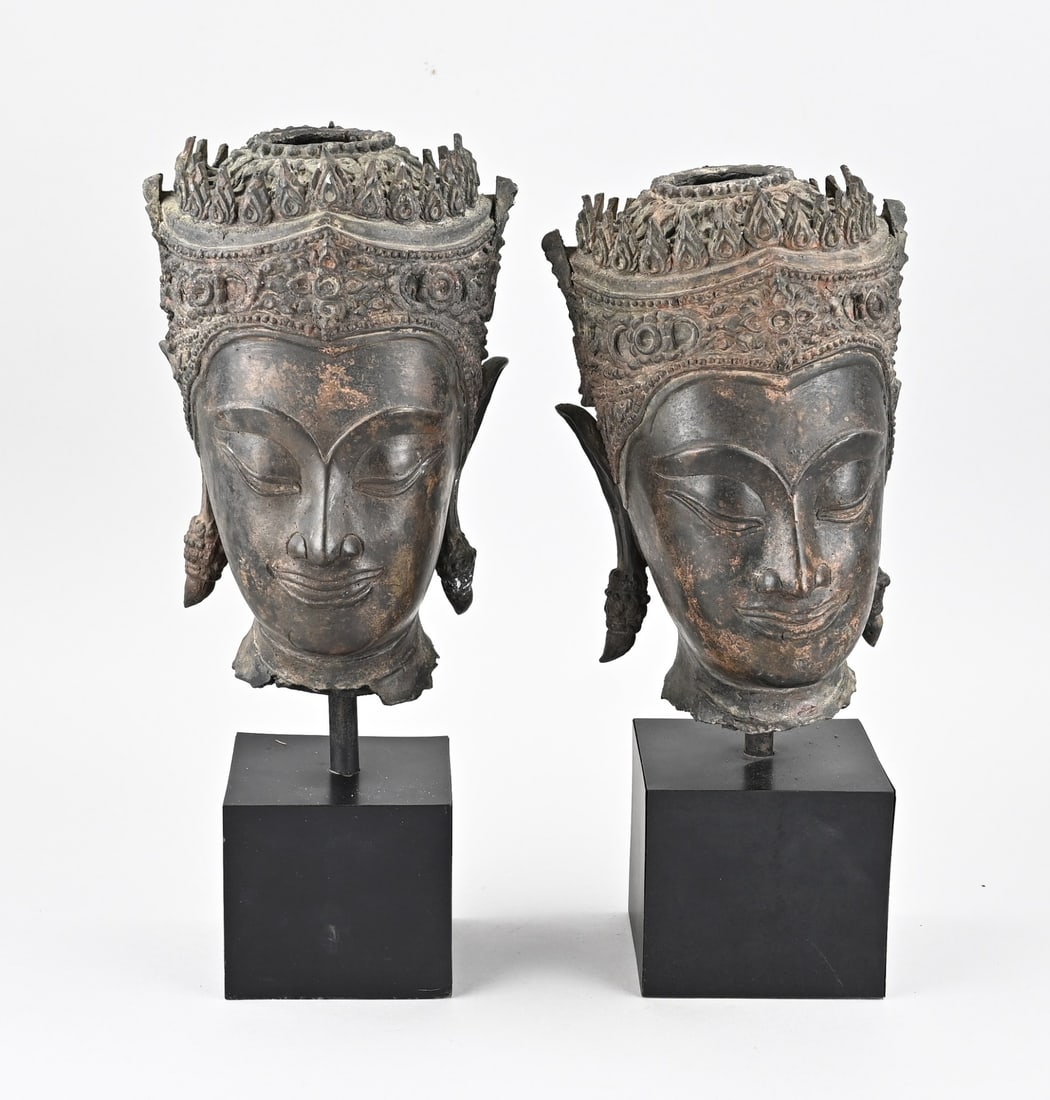 2x Buddha head: Two bronze Buddhas. Thailand. Probably based on an antique model. Mounted on a modern stand. Dimensions (heads): 23 - 24 cm. In good condition.