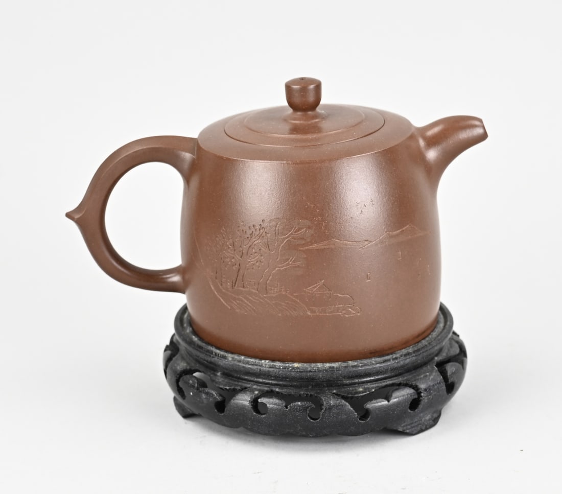 Yixing teapot on console: Beautiful old Chinese Yixing teapot on a console, with carved landscape decoration and text. With base mark. Dimensions: 11 x 18 x 10.5 cm. In good condition.