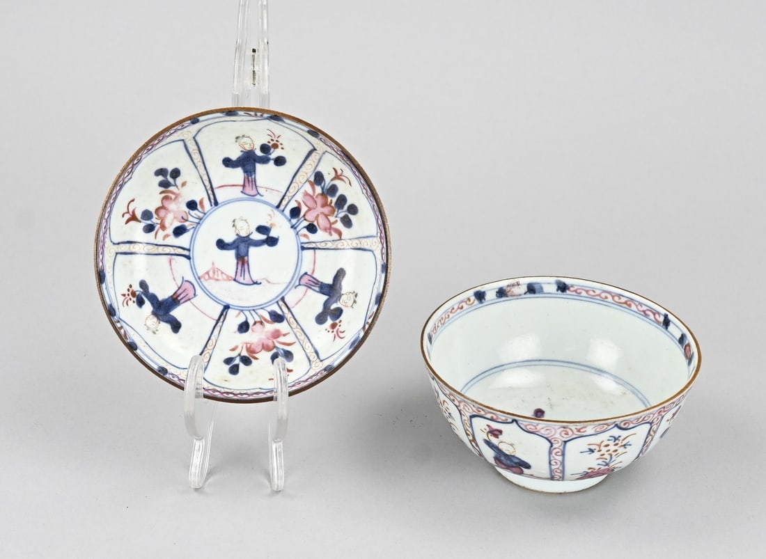 Chinese cup + saucer: 17th - 18th Century Chinese porcelain cup and saucer, with floral and jester decoration. Dimensions: 6.5 x 11.7 cm. Saucer has a hairline crack. In fair/good condition.