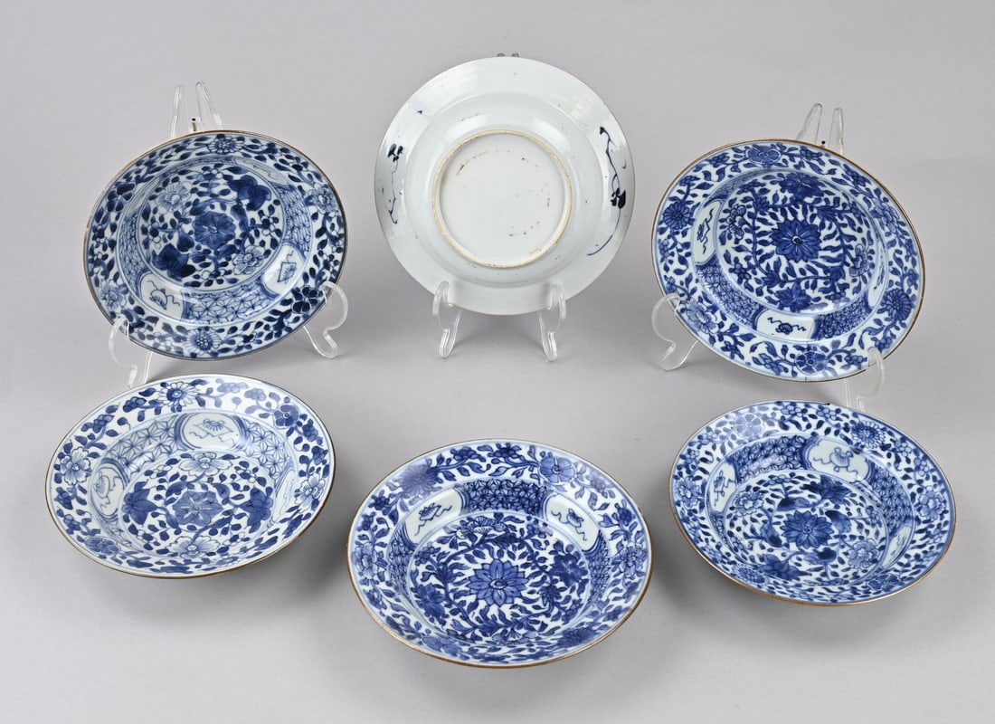 Set of Kang Xi porridge plates (6x): Set of six Chinese porcelain porridge plates with floral/lucky symbol decoration. Dimensions: Ø 16.7 cm. Four plates in good condition. One plate has chips. One plate has a hairline crack. In