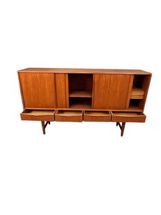 This beautiful teak sideboard is a stunning example of mid-century modern design. The piece features: Dimensions: 45 inches in height, 77 inches in length, and 17.5 inches in width, making it the ideal size for any room. The cabinet's sleek design and clean lines are perfect for any modern home, while