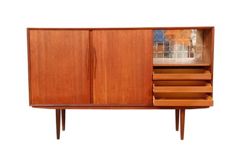 A Danish mid century bar buffet in teak.: Dimensions:W69&rdquo; x D17 x 43&rdquo; A Danish mid century bar buffet in teak. Three sliding doors reveal storage shelves left and center, and a mini bar area and three drawers to the right.