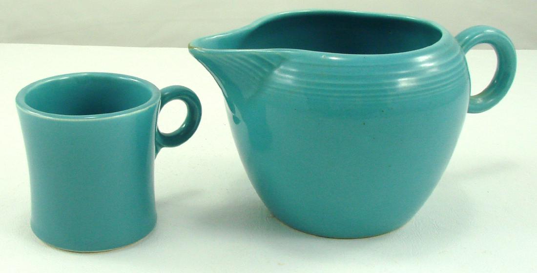 VINTAGE FIESTA TWO PINT JUG & TOM and JERRY MUG: Both Turquoise; (1) 2-Pint Jug: ring handle, impressed mark "H L C Fiesta Made in USA", interior crazing; L-8 1/2", H-4 1/4", VG+; (1) Tom & Jerry Mug: ring handle; ink stamp "Genuine Fiesta H L Co US