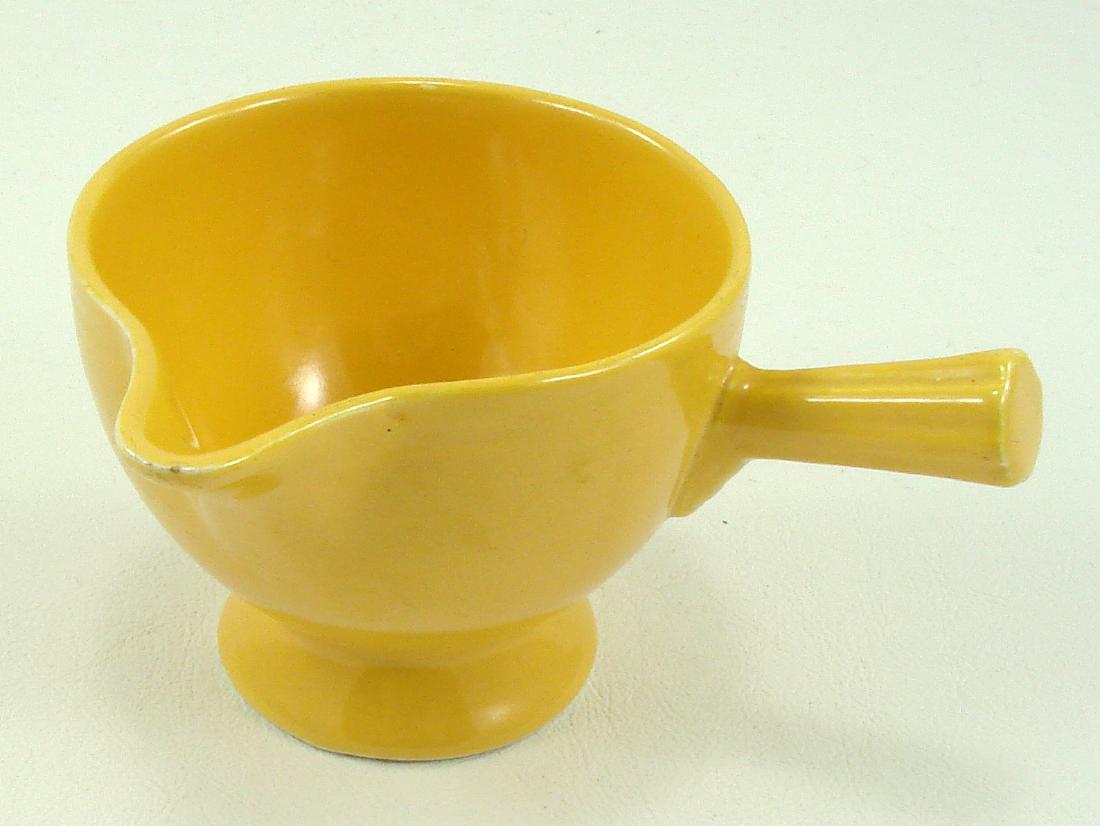 VINTAGE FIESTA STICK HANDLE CREAMER: Yellow, fleabite on lip, impressed "Fiesta HLC USA" mark; L-5 1/8", VG