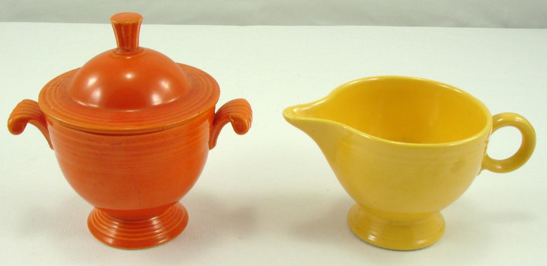 VINTAGE FIESTA CREAM & SUGAR: (1) Yellow ring handle creamer, impressed "HLC (monogram)Fiesta Made in USA"; L-5 7/8"; (1) red covered sugar, with impressed "H L C Fiesta Made in USA" mark; H-5", EX