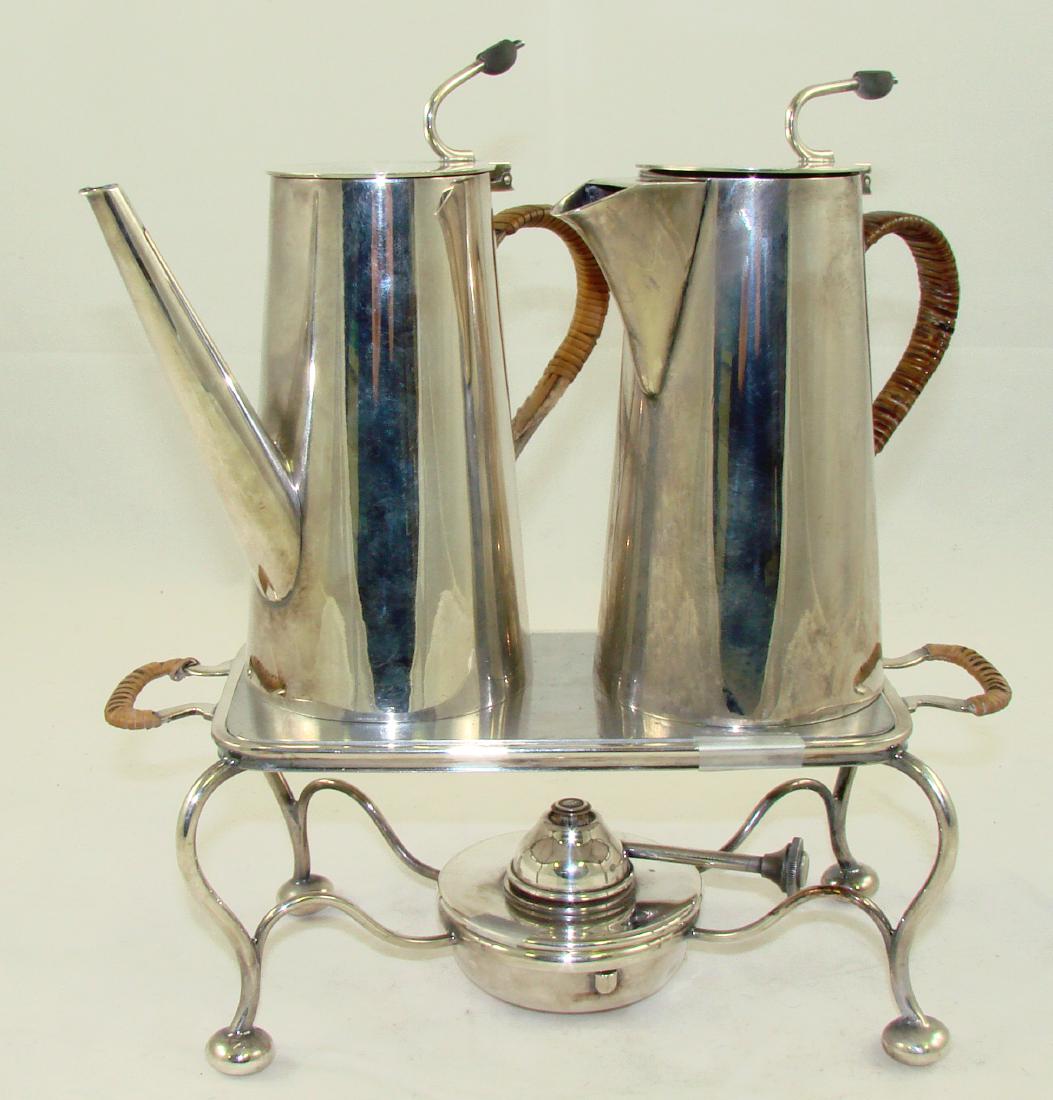 CHRISTOPHER DRESSER STYLE (3) PIECE COFFEE SET: Silverplate, includes coffee pot, teapot, and warming plate; coffee pot with long spout has a minor ding on body; minor rim dent and wicker unravelling on handle; minor ding on warmer; one handle on w