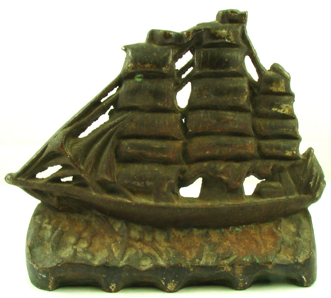 SAILING TALL SHIP DOORSTOP: Cast iron; very little trace of paint; triple masted schooner on waves; some surface rust; L-11 1/4", G